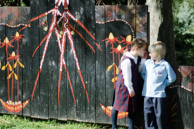 Kinder students playing near the mural